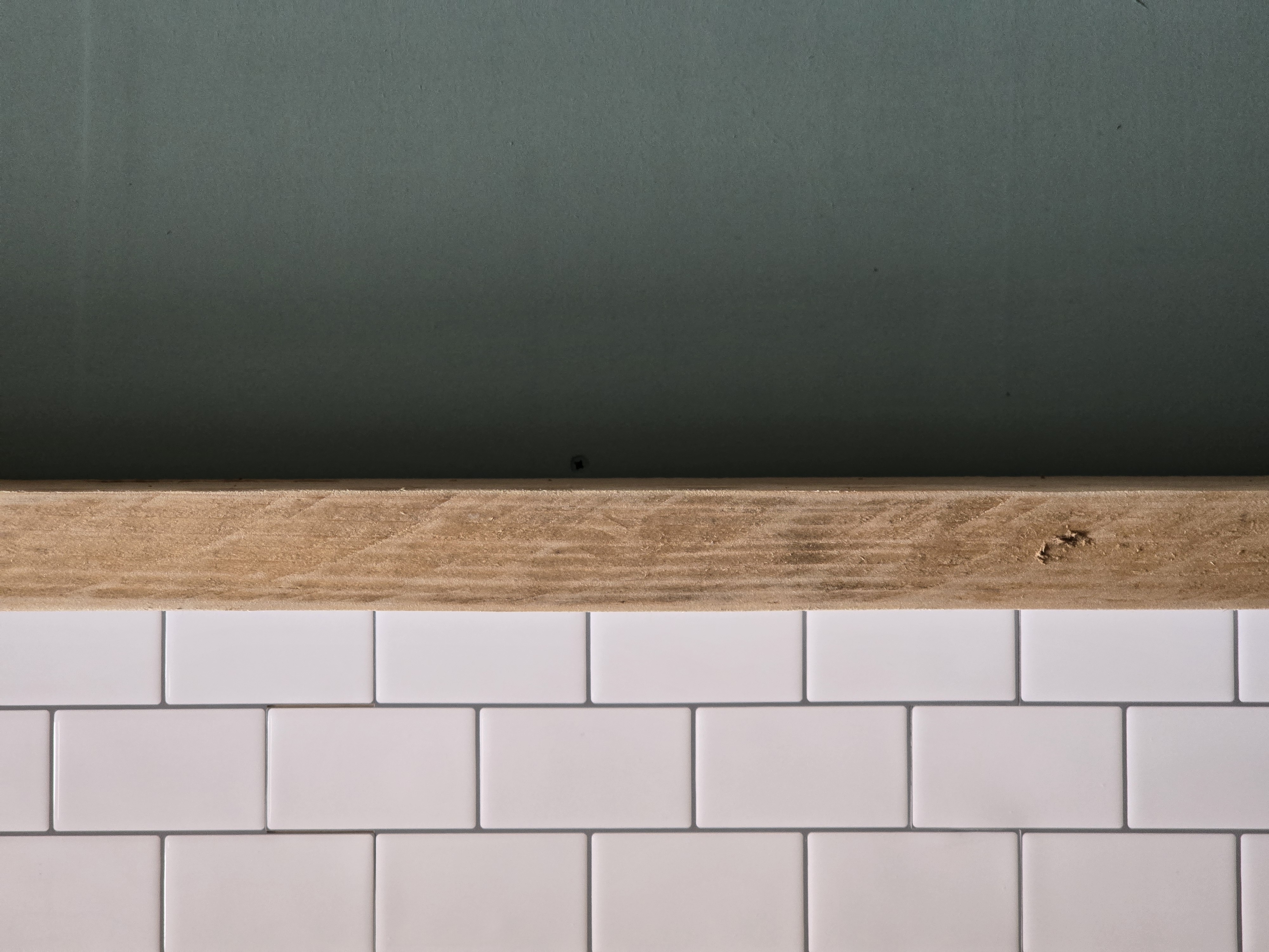 White subway tiles, oak ledge, sage green wall — the horsebox interior taking shape